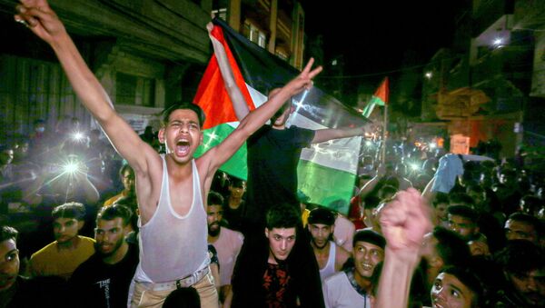 Palestinians celebrate in the streets following a ceasefire, in the southern Gaza Strip May 21, 2021. - Sputnik International