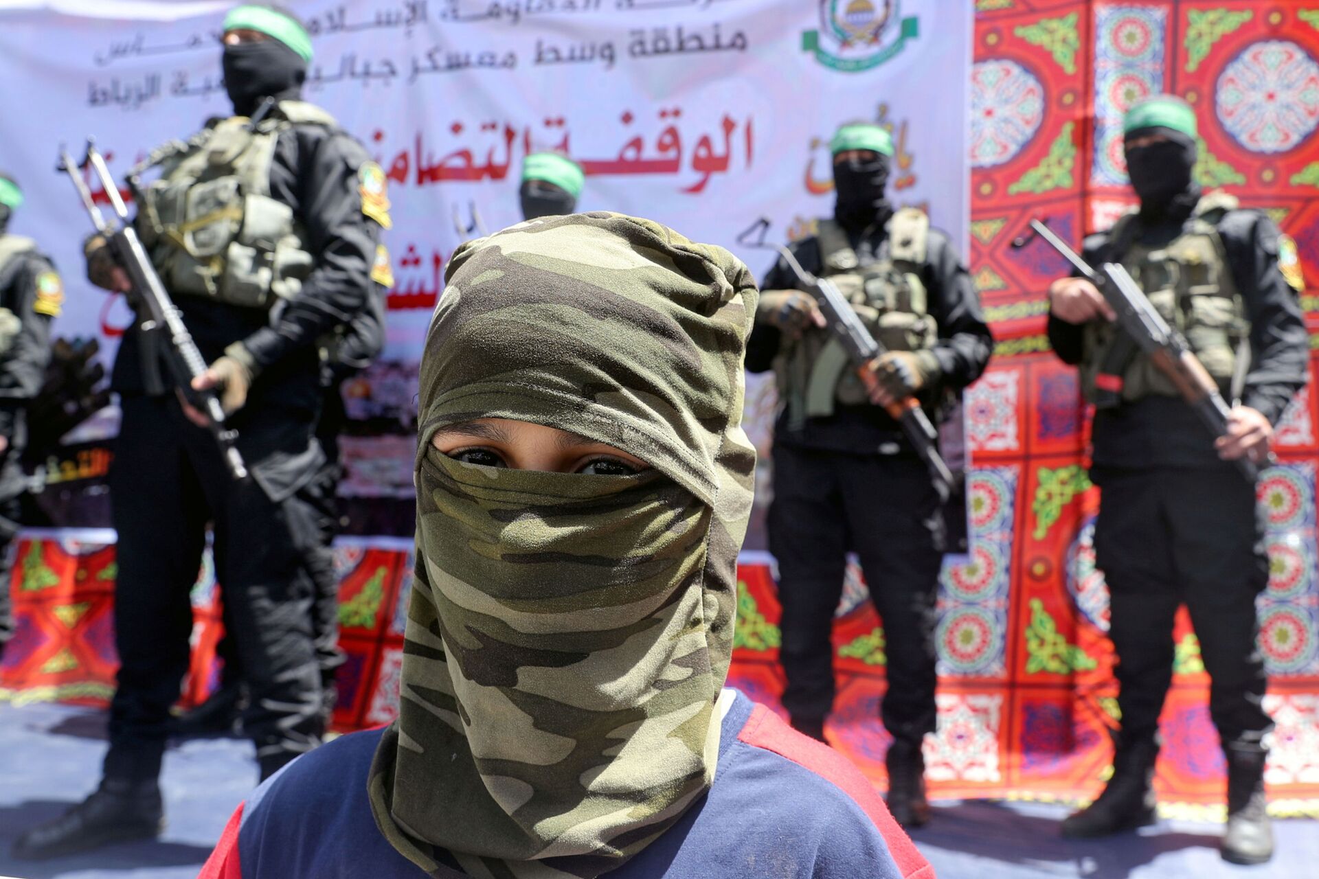 A masked Palestinian boy looks on as Hamas militant take part in a protest over the possible eviction of several Palestinian families from homes on land claimed by Jewish settlers in the Jerusalem's Sheikh Jarrah neighbourhood, in the northern Gaza Strip May 7, 2021 - Sputnik International, 1920, 29.03.2022