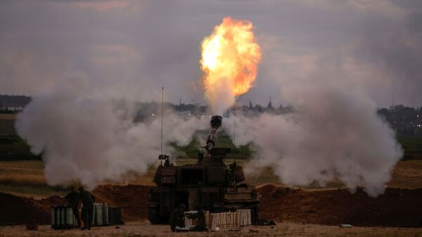 Israeli soldiers work at an artillery unit as it fires near the border between Israel and the Gaza strip, on the Israeli side May 17, 2021 - Sputnik International