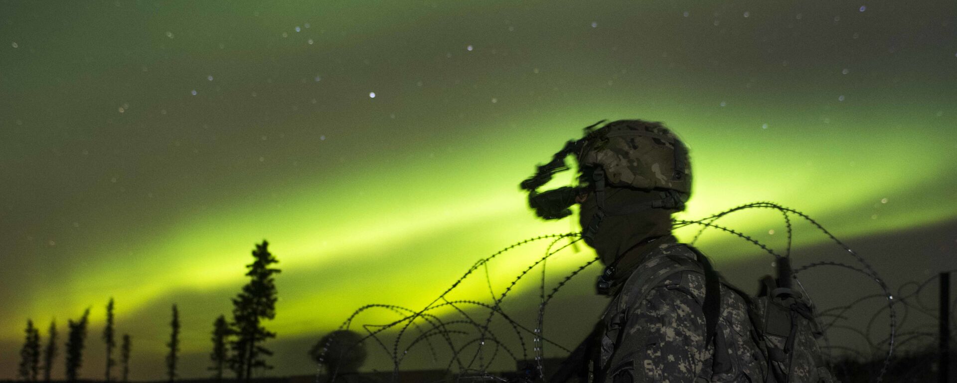 In this Oct. 25, 2016 photo provided by the U.S. Army Alaska, paratroopers secure an area in view of the aurora borealis, or northern lights, during night live-fire training at Fort Greely, Alaska. The battalion spent much of Exercise Spartan Cerberus in subzero temperatures training in Arctic, airborne and infantry tasks.  - Sputnik International, 1920, 24.12.2023