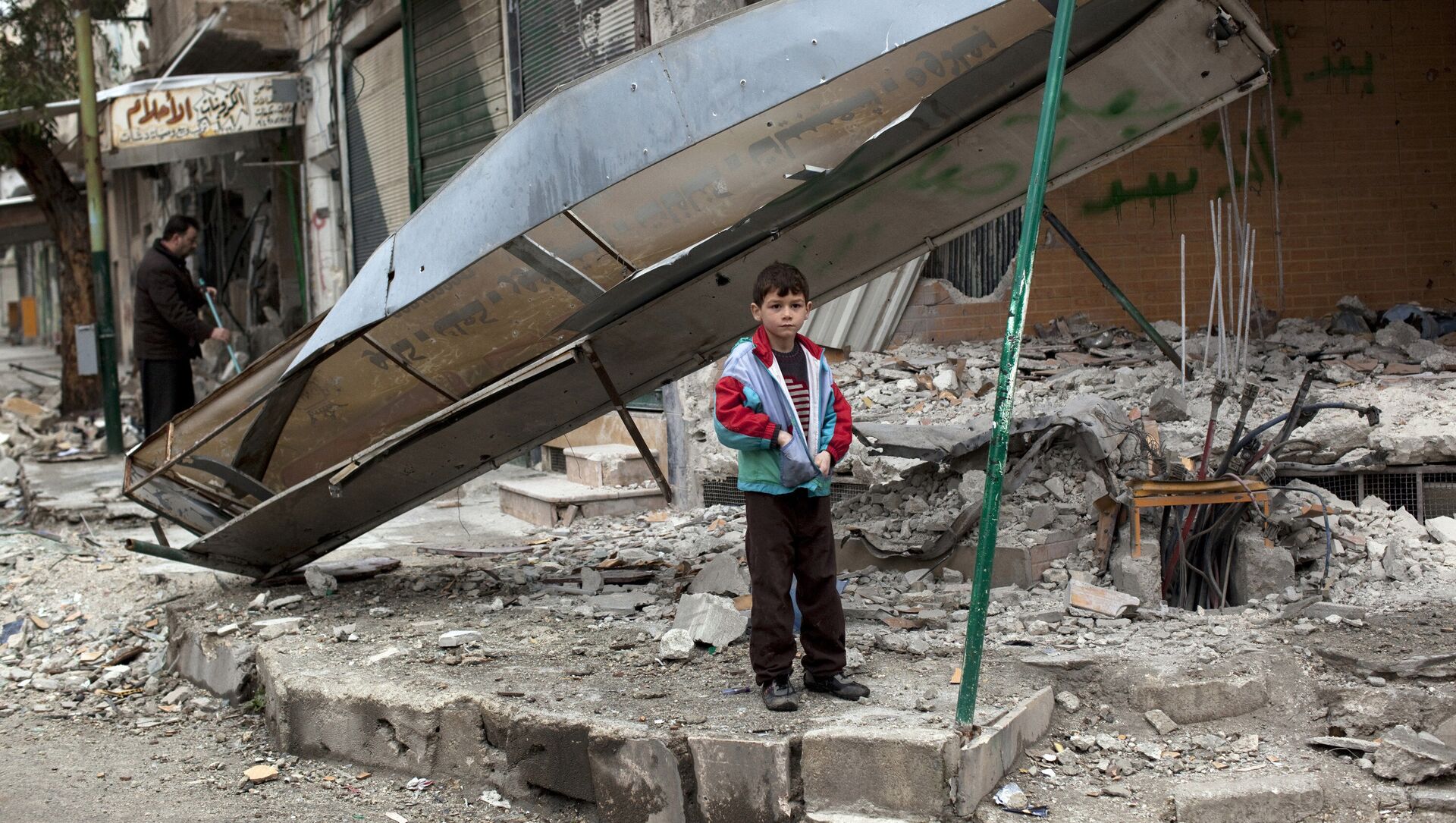 In this Monday, Feb. 27, 2012 file photo, a boy stands in from of a shop destroyed in Syrian Army shelling in the center of Idlib, in northern Syria. - Sputnik International, 1920, 25.05.2021