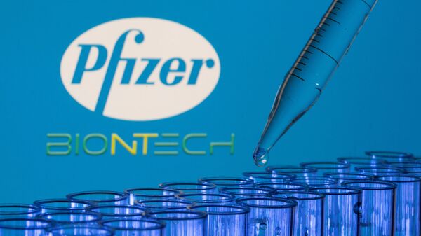 Test tubes are seen in front of displayed Pfizer and Biontech logos in this illustration taken, May 21, 2021. - Sputnik International