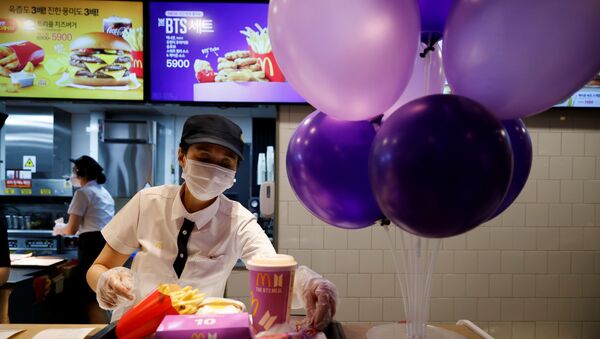 An employee of McDonald's serves a BTS meal, which is inspired and promoted by K-pop boy band BTS, during lunch hour at its restaurant in Seoul, South Korea, May 27, 2021 - Sputnik International