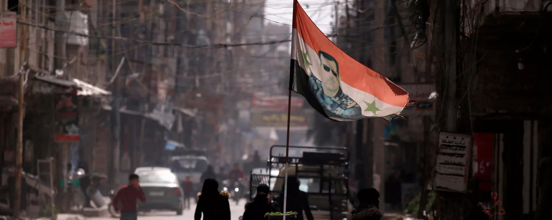 A national flag depicting a picture of Syria's President Bashar al-Assad flutters at a checkpoint in Douma, in the eastern suburbs of Damascus, Syria March 10, 2021. Picture taken March 10, 2021. - Sputnik International, 1920, 25.06.2021