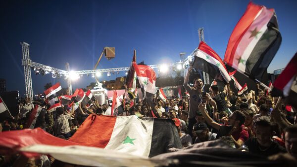 Syrian President Bashar Assad supporters hold up national flags and pictures of Assad as they celebrate at Omayyad Square, in Damascus, Syria, Thursday, May 27, 2021. - Sputnik International