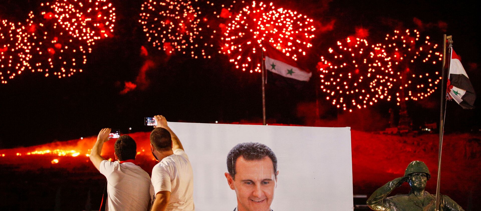 A poster depicting Syria’s president Bashar al- Assad is seen as supporters of of Syria's President Bashar al-Assad celebrate after the results of the presidential election announced that he won a fourth term in office, in Damascus, Syria, May 27, 2021. - Sputnik International, 1920, 27.05.2021