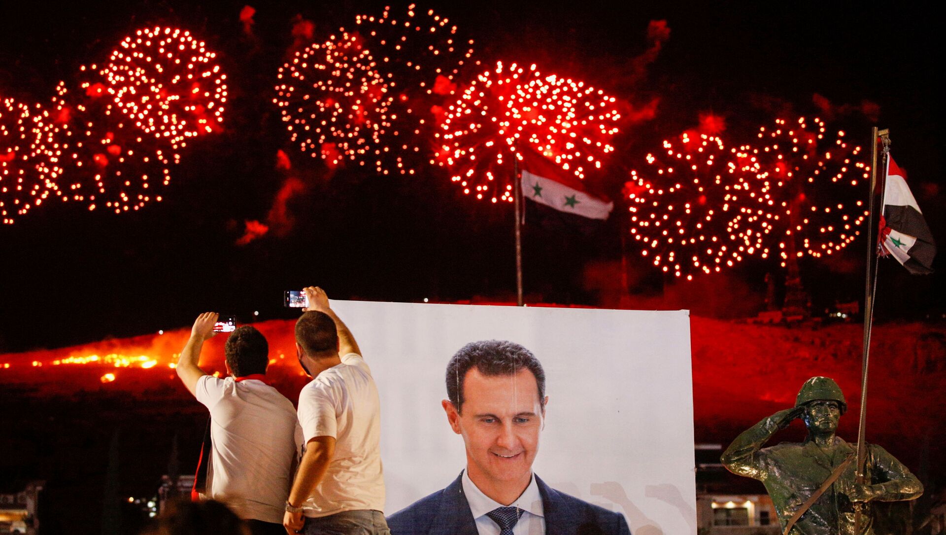 A poster depicting Syria’s president Bashar al- Assad is seen as supporters of of Syria's President Bashar al-Assad celebrate after the results of the presidential election announced that he won a fourth term in office, in Damascus, Syria, May 27, 2021. - Sputnik International, 1920, 27.05.2021