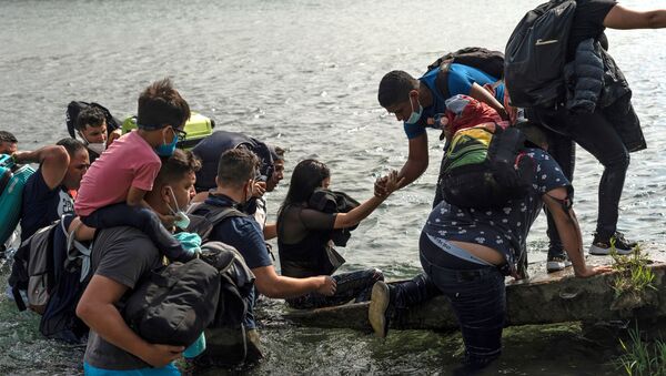 Asylum-seeking migrants cross the Rio Grande river in Del Rio - Sputnik International