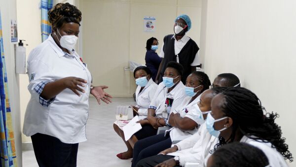 A health worker talks to her colleagues as they prepare to receive the AstraZeneca/Oxford vaccine under the COVAX scheme against coronavirus disease (COVID-19) at the Kenyatta National Hospital in Nairobi, Kenya March 5, 2021. - Sputnik International