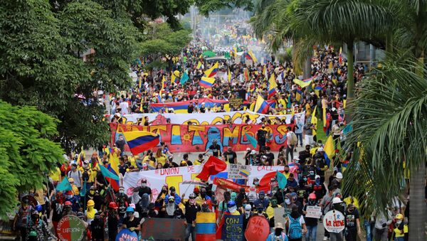 People take part in a protest demanding government action to tackle poverty, police violence and inequalities in healthcare and education systems, in Cali, Colombia May 28, 2021.  - Sputnik International