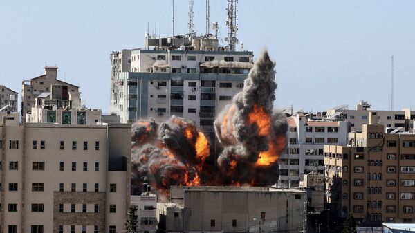 Smoke billows from a building housing various international media, including The Associated Press, after an Israeli airstrike on Saturday, May 15, 2021 in Gaza City. - Sputnik International