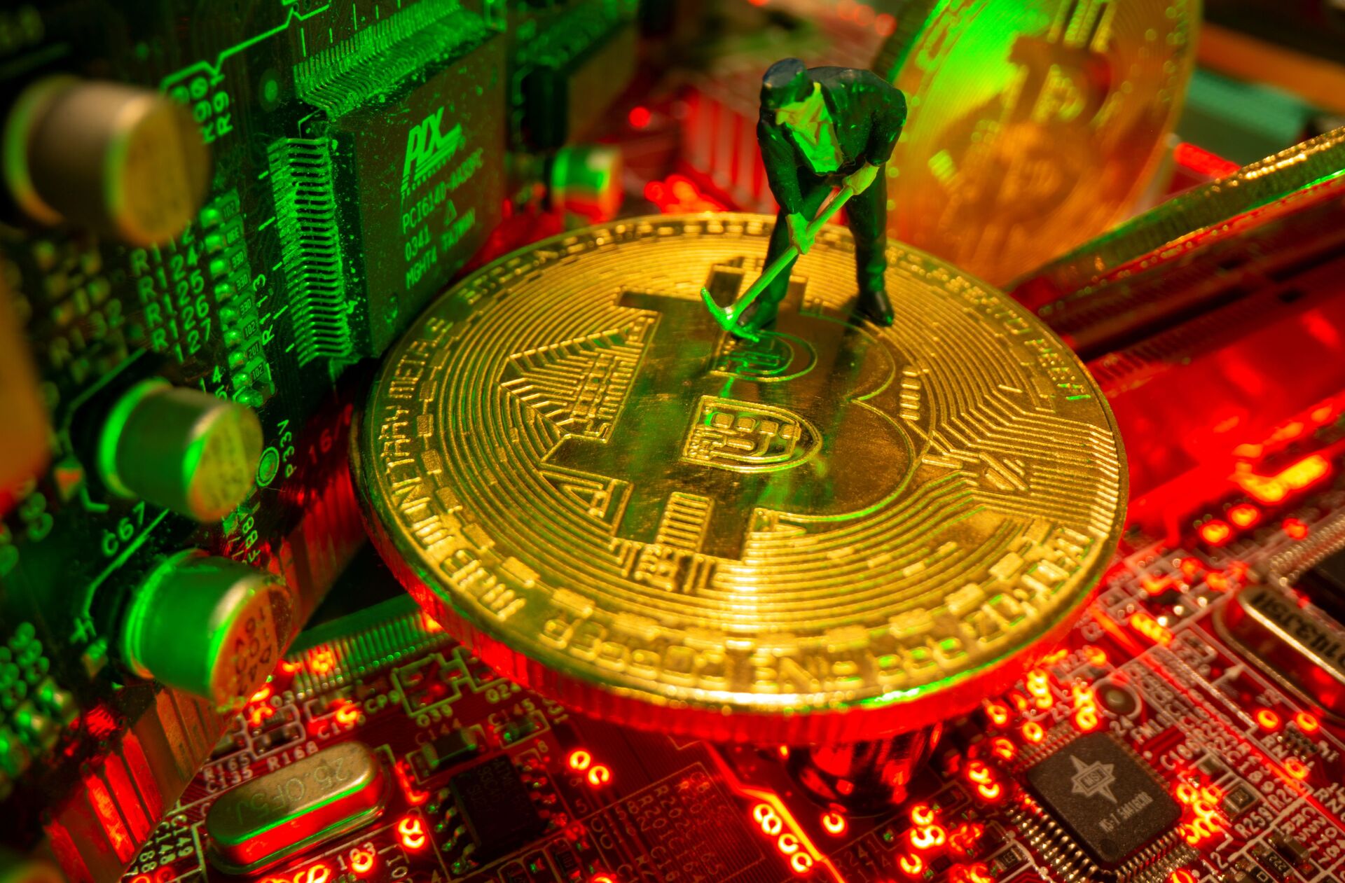 A small toy figure and representations of the virtual currency Bitcoin stand on a motherboard in this picture illustration taken May 20, 2021. - Sputnik International, 1920, 14.10.2021