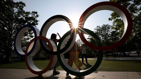 Visitors try to take photos in front of the Olympic Rings monument outside the Japan Olympic Committee (JOC) headquarters near the National Stadium, the main stadium for the 2020 Tokyo Olympic Games that have been postponed to 2021 due to the coronavirus disease (COVID-19) outbreak, in Tokyo, Japan May 30, 2021. - Sputnik International