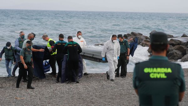 Workers carry a coffin containing a body at the shore near the Spanish-Moroccan border at El Tarajal Beach, after thousands of migrants swam across this border during the last days, in Ceuta, Spain, May 20, 2021 - Sputnik International