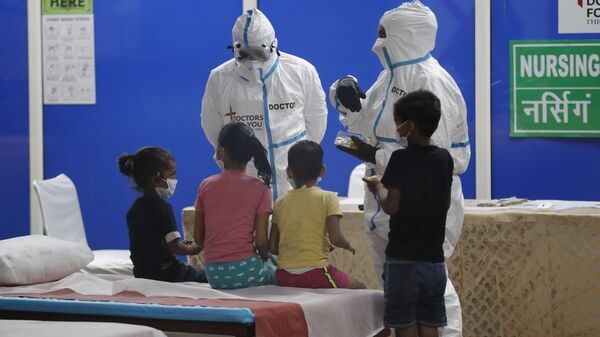 Doctors and health workers entertain children at a COVID-19 care center built in an indoor stadium in New Delhi, India, Monday, July 20, 2020 - Sputnik International