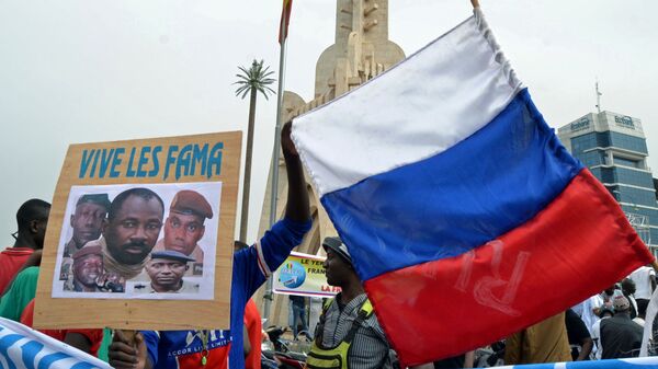 Malians holds a photograph with an image of coup leader Colonel Assimi Goita, who overthrew the president and prime minister this week, and Russia's flag during a pro-Malian Armed Forces (FAMA)  demonstration in Bamako, Mali, May 28, 2021 - Sputnik International