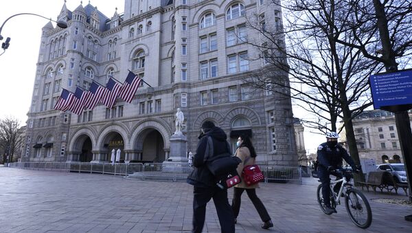 People walk by and a police officer rides a bicycle near The Trump International Hotel, Thursday, March 4, 2021, in Washington - Sputnik International