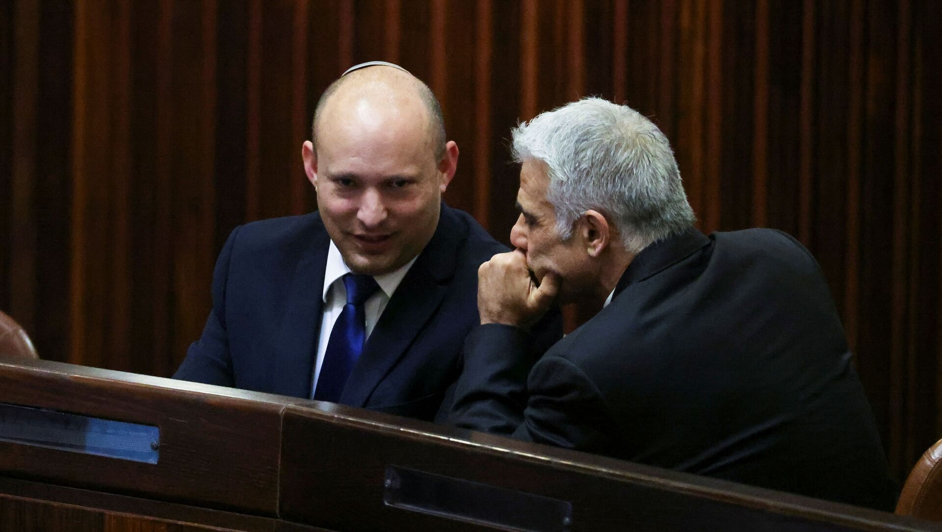 Yamina party leader Naftali Bennett smiles as he speaks to Yesh Atid party leader Yair Lapid, during a special session of the Knesset whereby Israeli lawmakers elect a new president, at the plenum in the Knesset, Israel's parliament, in Jerusalem June 2, 2021.  - Sputnik International, 1920, 02.06.2021