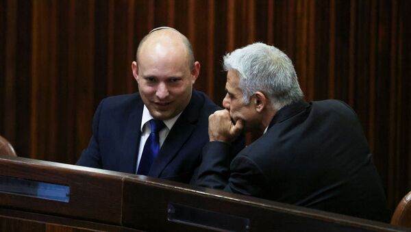 Yamina party leader Naftali Bennett smiles as he speaks to Yesh Atid party leader Yair Lapid, during a special session of the Knesset whereby Israeli lawmakers elect a new president, at the plenum in the Knesset, Israel's parliament, in Jerusalem June 2, 2021.  - Sputnik International