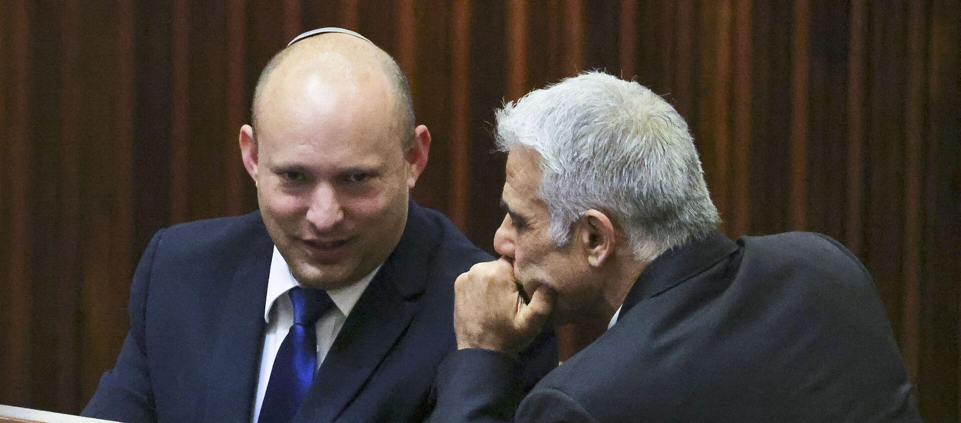 Israel's Yamina party leader, Naftali Bennett (L), smiles as he speaks to Yesh Atid party leader, Yair Lapid, during a special session of the Knesset, Israel's parliament, to elect a new president, in Jerusalem on 2 June 2021. Israeli politicians battling to unseat veteran right-wing Prime Minister Benjamin Netanyahu - who has been in charge for 12 years, making him Israel's longest-running premier - were locked in last-ditch talks on today to hammer out their change coalition composed of bitter ideological rivals with a razor-thin majority. - Sputnik International, 1920, 03.06.2021