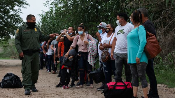 Migrants from Venezuela await transportation to a U.S. border patrol facility after crossing the Rio Grande river into the United States from Mexico in Del Rio, Texas, U.S., May 11, 2021 - Sputnik International