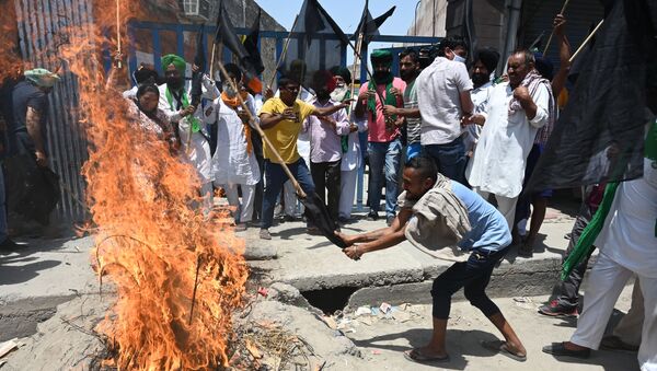 Farmers holding black flags shout slogans as they burn an effigy of Prime Minister Narendra Modi while they observe a 'Black Day' marking six months of continued protest against the central government's agricultural reforms, at the Delhi-Haryana state border in Kundli on May 26, 2021.  - Sputnik International
