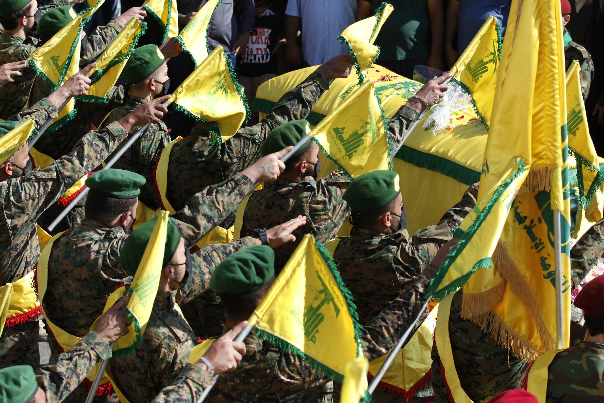 Hezbollah fighters raise their group flags, as they salut the coffin of their comrade Mohammed Tahhan who was shot dead on Friday by Israeli forces along the Lebanon-Israel border, during his funeral procession, in the southern village of Adloun, Lebanon, Saturday, May 15, 2021 - Sputnik International, 1920, 07.09.2021