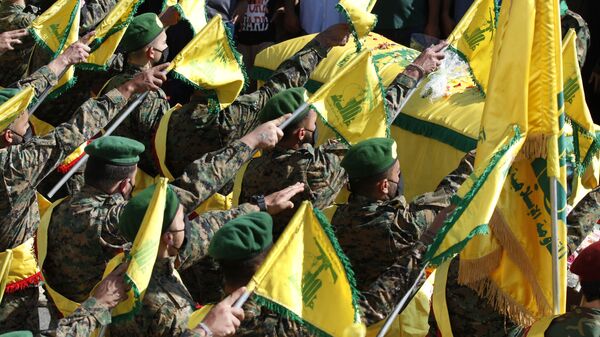 Hezbollah fighters raise their group flags, as they salut the coffin of their comrade Mohammed Tahhan who was shot dead on Friday by Israeli forces along the Lebanon-Israel border, during his funeral procession, in the southern village of Adloun, Lebanon, Saturday, 15 May 2021 - Sputnik International
