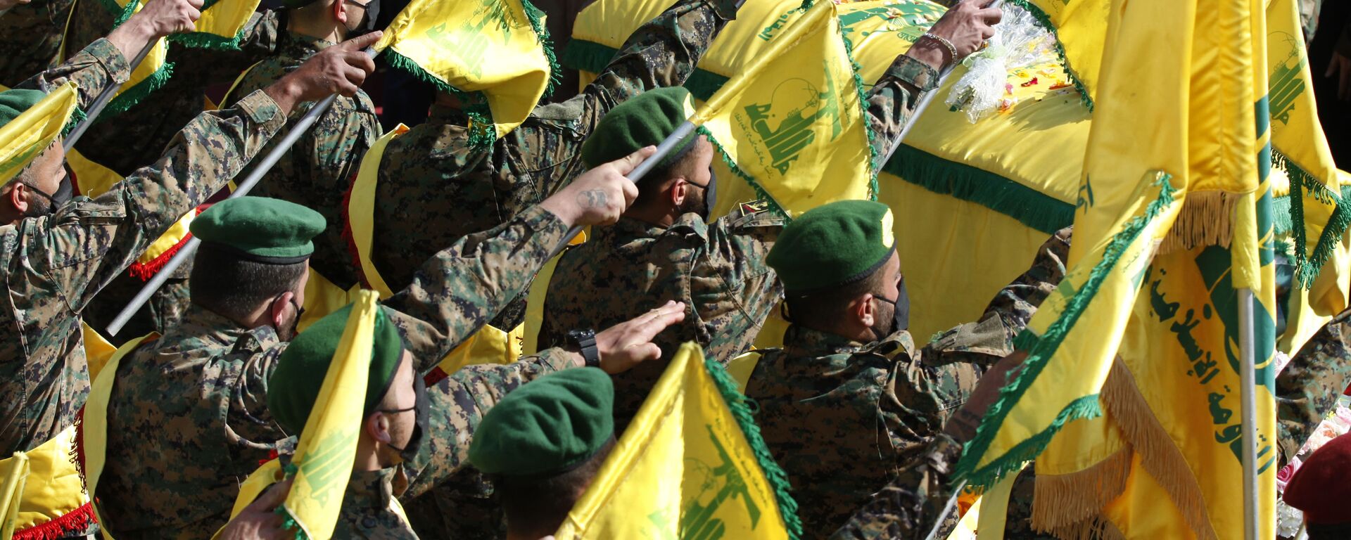 Hezbollah fighters raise their group flags, as they salut the coffin of their comrade Mohammed Tahhan who was shot dead on Friday by Israeli forces along the Lebanon-Israel border, during his funeral procession, in the southern village of Adloun, Lebanon, Saturday, 15 May 2021 - Sputnik International, 1920, 13.08.2021
