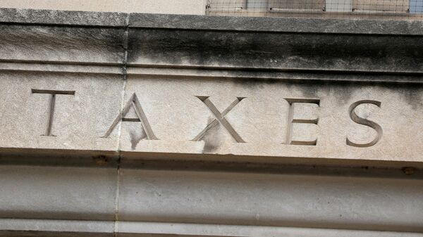 The word taxes is seen engraved at the headquarters of the Internal Revenue Service (IRS) in Washington, D.C., U.S., May 10, 2021. - Sputnik International