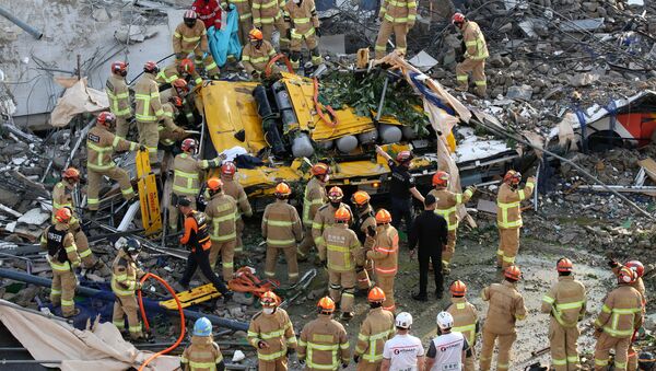 South Korean firefighters search for passengers from a bus trapped by the debris of a collapsed building in Gwangju, South Korea, June 9, 2021. - Sputnik International
