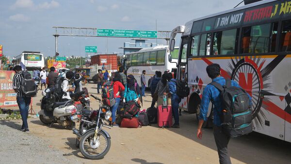 People wait on the outskirts of Bangalore to board buses and return to their home towns on the border of the states of Karnataka and Tamil Nadu, as another lockdown looms to tackle the surge in COVID-19 coronavirus cases on 13 July 2020. - Sputnik International