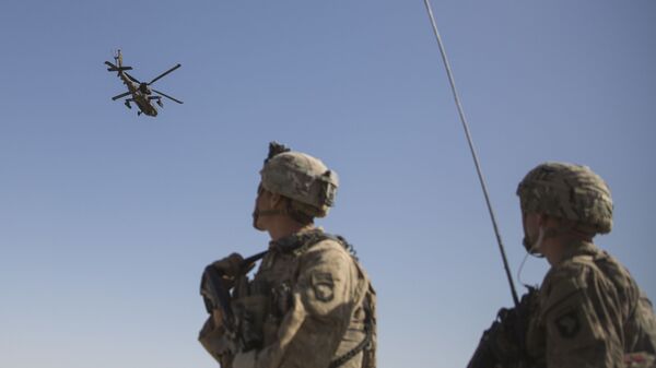 This June 10, 2017 photo released by the U.S. Marine Corps shows an AH-64 Apache attack helicopter provides security from above while CH-47 Chinooks drop off supplies to U.S. Soldiers with Task Force Iron at Bost Airfield, Afghanistan. - Sputnik International