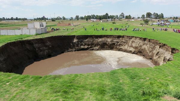 An aerial view of a sinkhole found in a farmland in Santa Maria Zacatepec, Puebla, Mexico May 30, 2021 is shown in this screen grab obtained from a social media video.  - Sputnik International