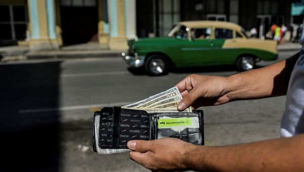 A man shows his wallet with US dollars in it in a street of Havana, on September 15, 2020 - Sputnik International