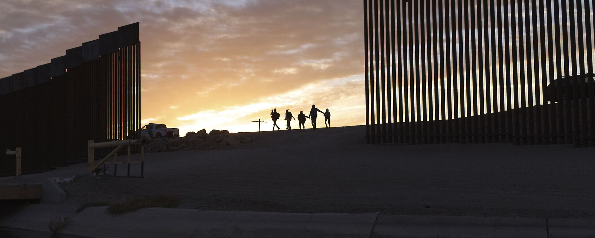 A pair of migrant families from Brazil pass through a gap in the border wall to reach the United States after crossing from Mexico in Yuma, Ariz., Thursday, June 10, 2021, to seek asylum. - Sputnik International, 1920, 28.12.2022