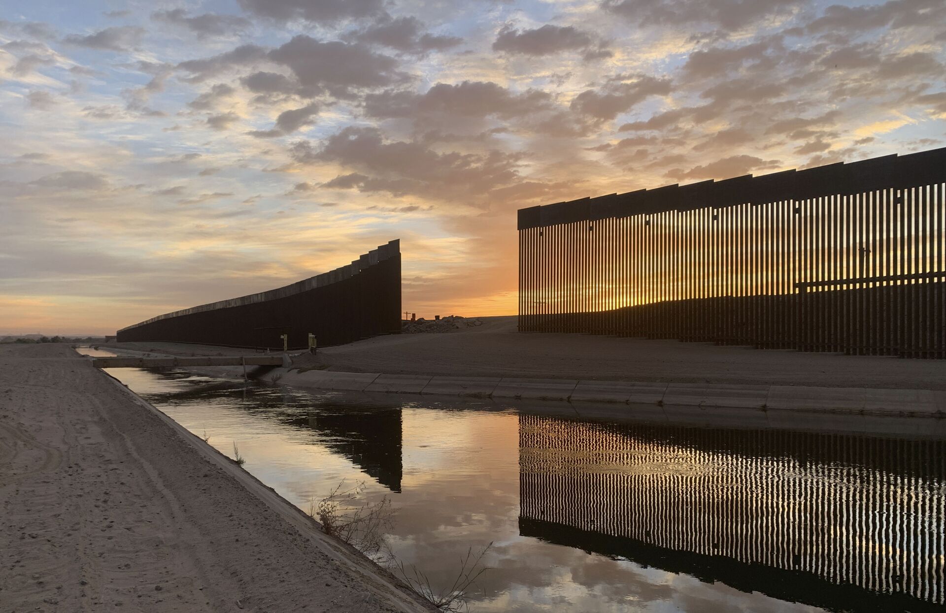 The sun sets above the U.S.-Mexico border wall, seen in Yuma, Ariz., Wednesday, June 9, 2021. - Sputnik International, 1920, 07.09.2021