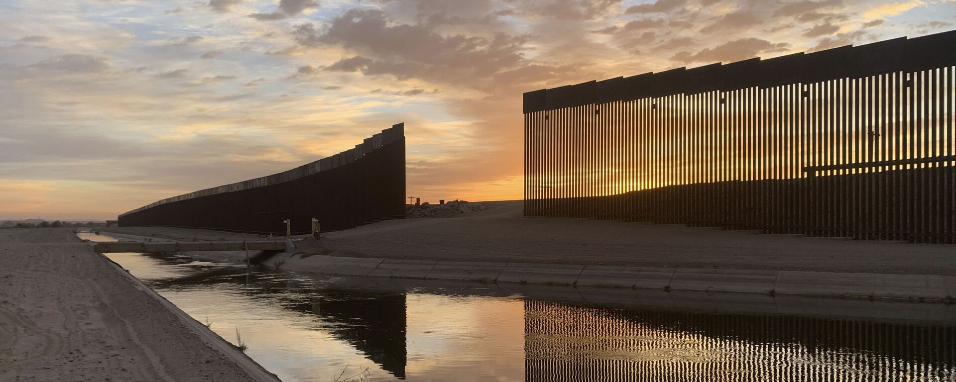 The sun sets above the U.S.-Mexico border wall, seen in Yuma, Ariz., Wednesday, June 9, 2021. - Sputnik International, 1920, 02.08.2021