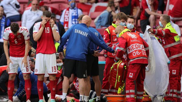 Denmark's players react as paramedics attend to Denmark's midfielder Christian Eriksen after he collapsed on the pitch during the UEFA EURO 2020 Group B football match between Denmark and Finland at the Parken Stadium in Copenhagen on June 12, 2021. - Sputnik International