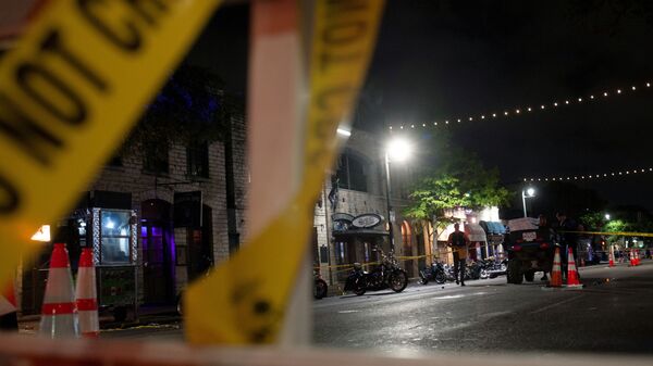 Police investigate the scene of a mass shooting in the Sixth Street entertainment district area of Austin, Texas, U.S. June 12, 2021. - Sputnik International
