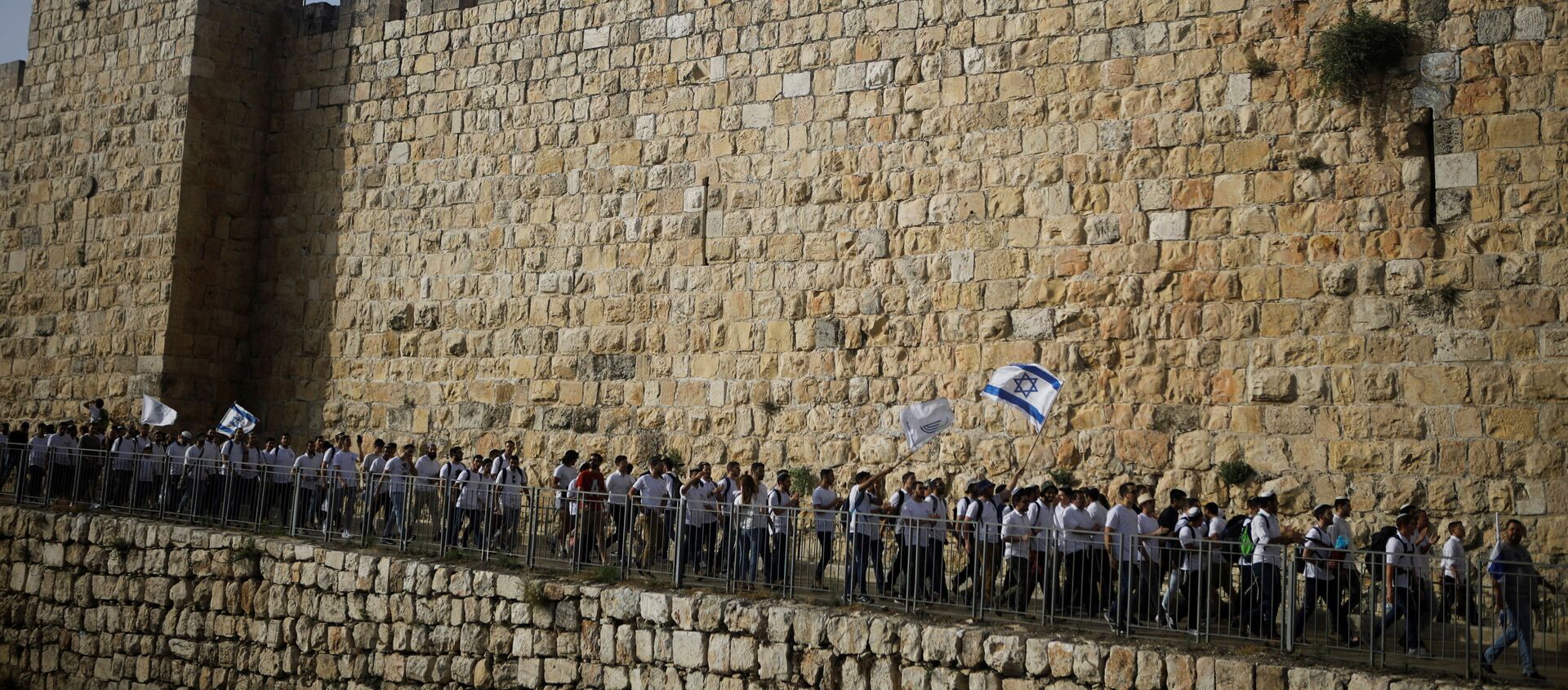 Youths wave Israeli flags during a parade marking Jerusalem Day amid Israeli-Palestinian tension as they march along the walls surrounding Jerusalem's Old City, May 10, 2021. REUTERS/Nir Elias/File Photo - Sputnik International, 1920, 16.08.2021