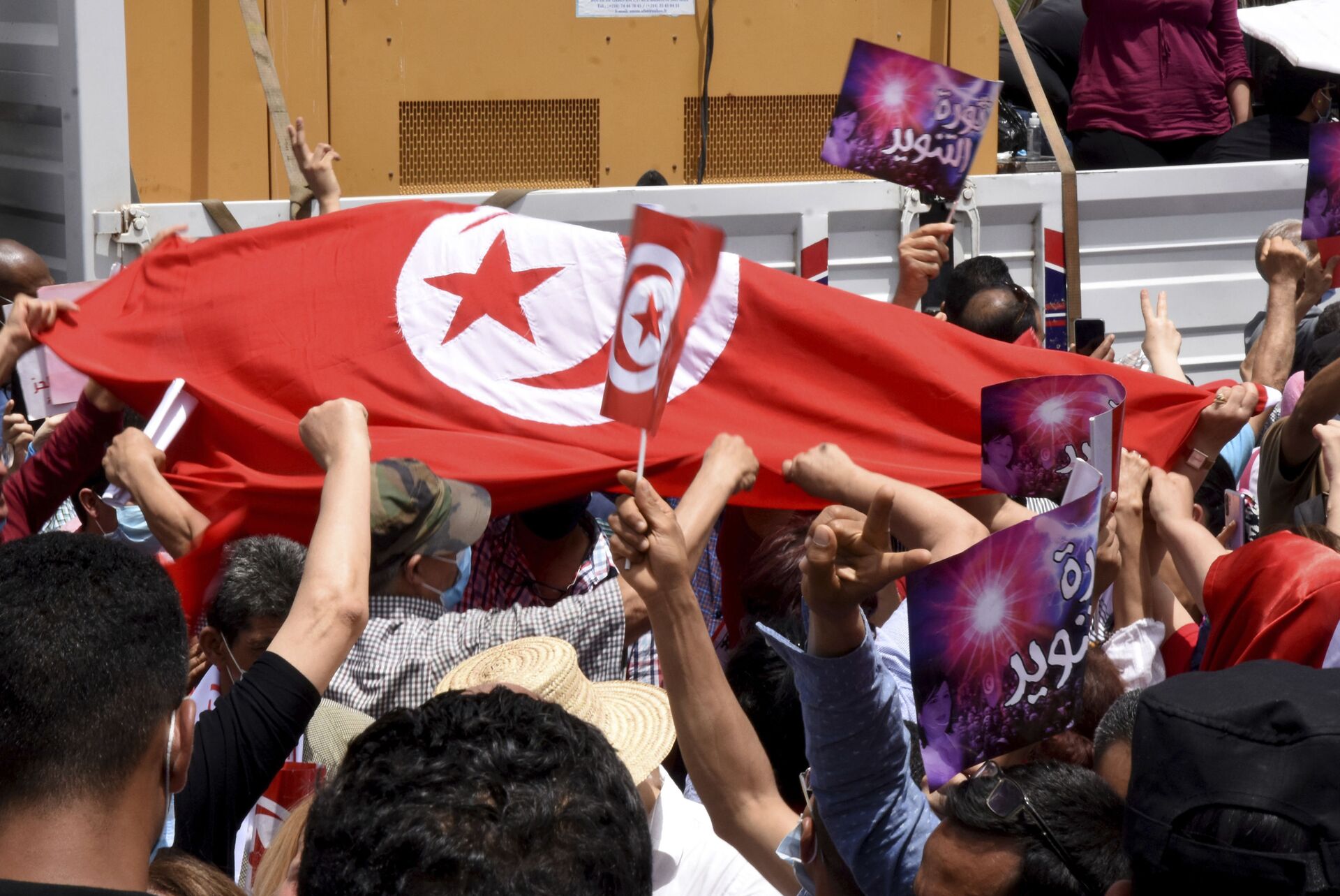 Demonstrators hold a Tunisian flag during a protest in Tunis, Saturday, June 5, 2021. Demonstrators will go to the streets of Tunis on Saturday to protest against the parliament and against the increase of the price in basic products announced this week by the government.  - Sputnik International, 1920, 25.06.2022