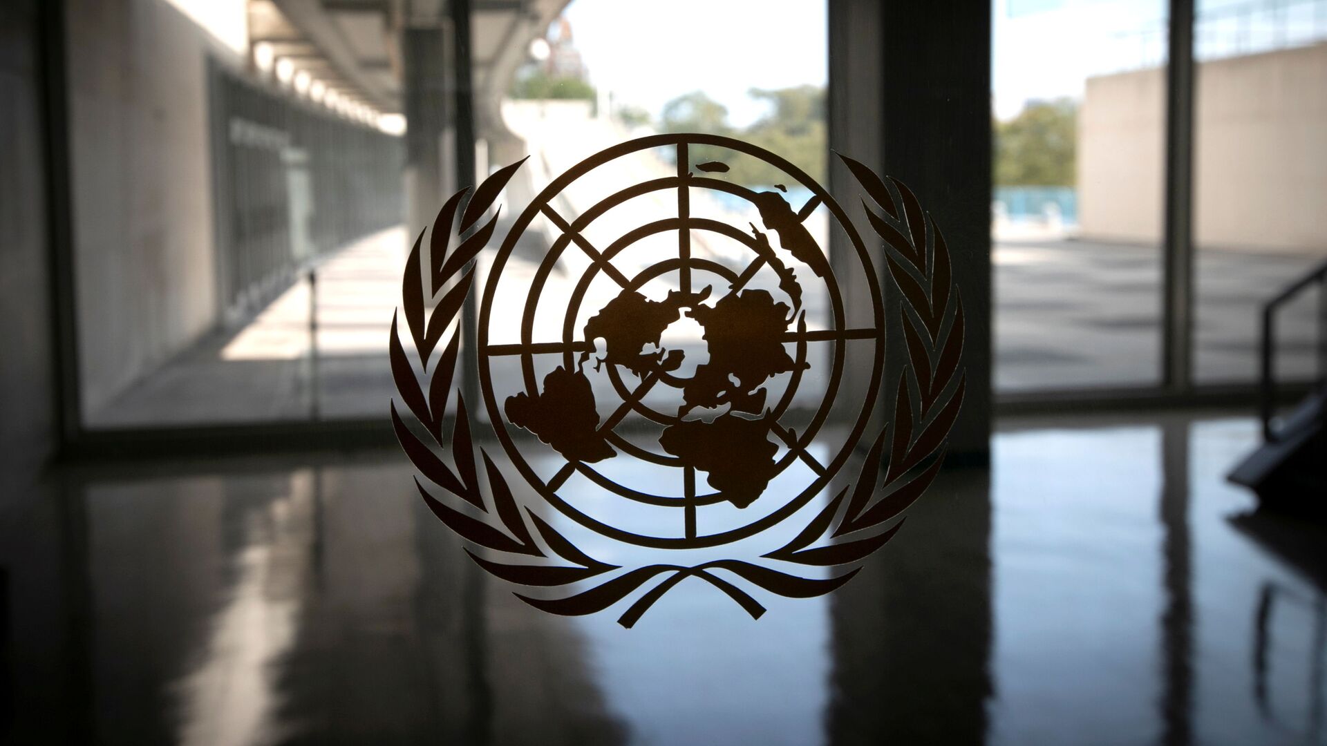 The United Nations logo is seen on a window in an empty hallway at United Nations headquarters during the 75th annual UN General Assembly high-level debate, which is being held mostly virtually due to the coronavirus disease (COVID-19) pandemic in New York, US, September 21, 2020 - Sputnik International, 1920, 13.09.2021