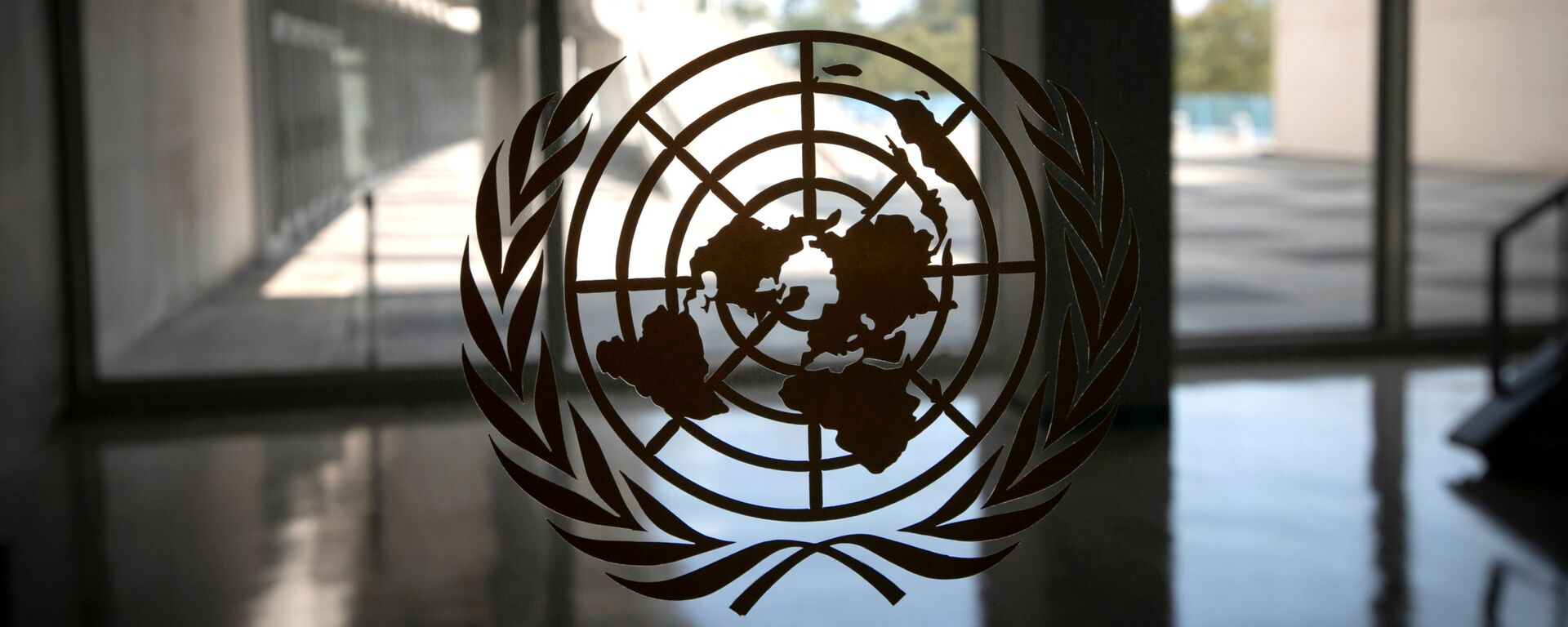 The United Nations logo is seen on a window in an empty hallway at United Nations headquarters during the 75th annual UN General Assembly high-level debate, which is being held mostly virtually due to the coronavirus disease (COVID-19) pandemic in New York, US, September 21, 2020 - Sputnik International, 1920, 20.01.2022