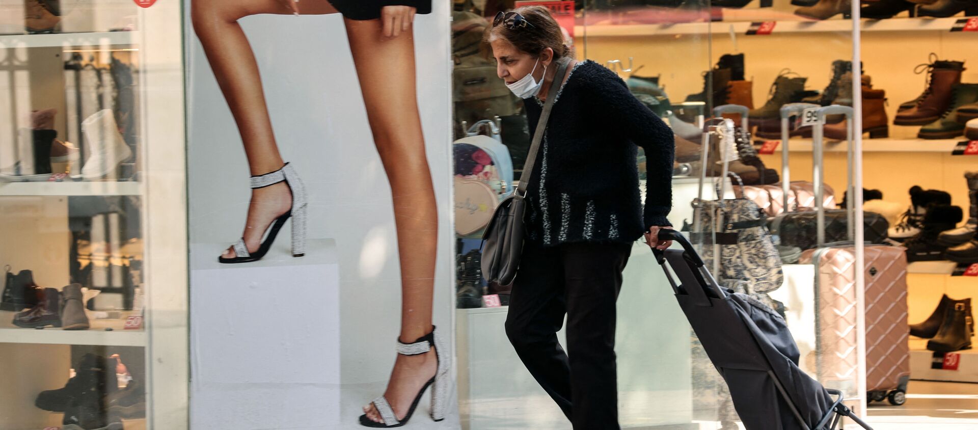 A woman walks past an open shoe store in the Israeli coastal city of Tel Aviv on February 7, 2021, following the lifting of a nationwide lockdown due to the COVID-19 pandemic.  - Sputnik International, 1920