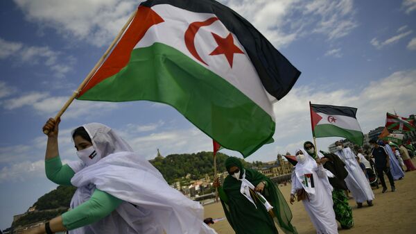 Saharan demonstrator wave their flags as they take part in a rally along the Concha beach support Brahim Gali, leader of the Polisario Front and a Sahara free, in San Sebastian, northern Spain, Sunday, May 30, 2021. Brahim Gali is recovering from COVID-19 in a Spanish hospital. The leader of the Western Sahara independence movement at the heart of a diplomatic spat between Spain and Morocco will appear before an investigating judge in Spain on June 1. - Sputnik International