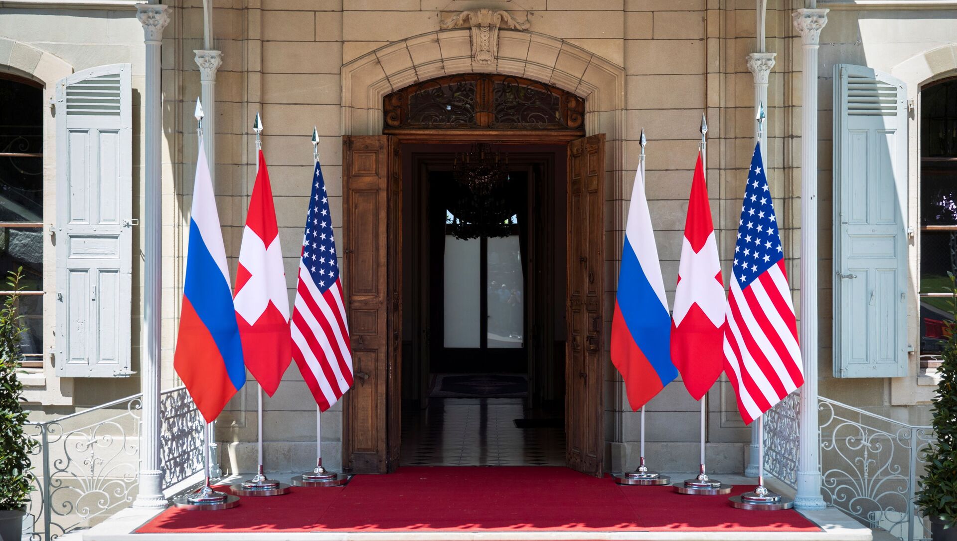 Flags of the U.S., Russia and Switzerland are pictured in front of the entrance of villa La Grange, one day prior to the meeting of U.S. President Joe Biden and Russian President Vladimir Putin in Geneva, Switzerland June 15, 2021 - Sputnik International, 1920, 16.06.2021