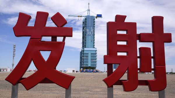 The Shenzhou-12 spacecraft sits covered on a launch pad near Chinese characters reading Launch at the Jiuquan Satellite Launch Center near Jiuquan, China on Wednesday, June 16, 2021 - Sputnik International