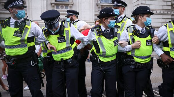Police officers apprehend a demonstrator during an anti-lockdown and anti-vaccine protest, amid the coronavirus disease (COVID-19) pandemic, in London, Britain, June 14, 2021. REUTERS - Sputnik International