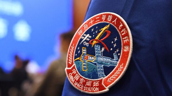 A staff member of the Jiuquan Satellite Launch Centre wears the logo of China's new space station during a press conference about the first crewed mission to the station, scheduled for June 17, at the Jiuquan Satellite Launch Centre in the Gobi desert in northwest China on June 16, 2021. - Sputnik International